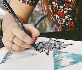 A person writing with a Sharpie pen