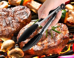 a hand holding a pair of cooking tongs