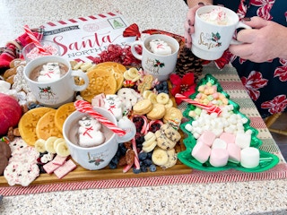 holiday charcuterie board with hot coco, cookies, and waffles