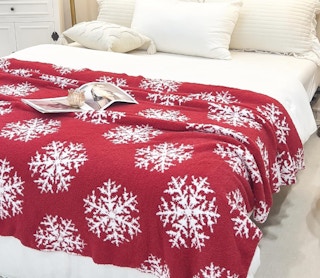 a red snowflake blanket on a bed
