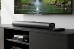 black sound bar and remote on an entertainment center