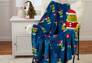 grinch holiday pillow and blanket sitting on a chair