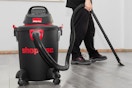 a man using a shop-vac on a floor