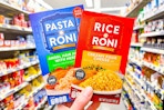 hand holdling rice-a-roni and pasta-roni boxes