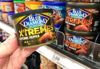 can of blue diamonds xtremes almonds held next to other flavor of spicy almonds and target price tag