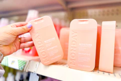 hand grabbing a bottle of monday shampoo