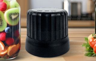 a vacuum sealer next to a jar of fruit