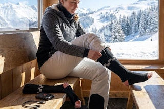 a woman putting on socks