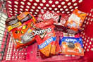 halloween candy, doritos, dr pepper, coffee, and oreos in a cart