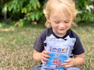 little boy holding diy kids workshop kits smiling