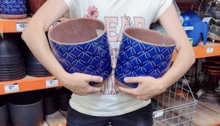 hands holding southern patio blue ceramic planters at home depot