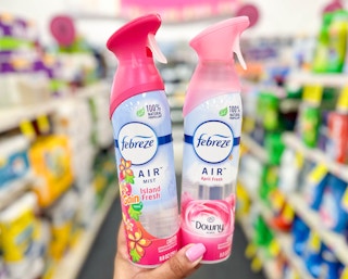 hand holding two bottles of Febreze Air Fresheners