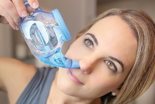 a person using a neti-pot