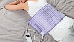 a person with a purple heating pad on their back