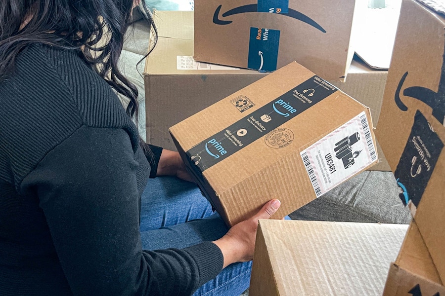 a person sitting on their couch holding an amazon box