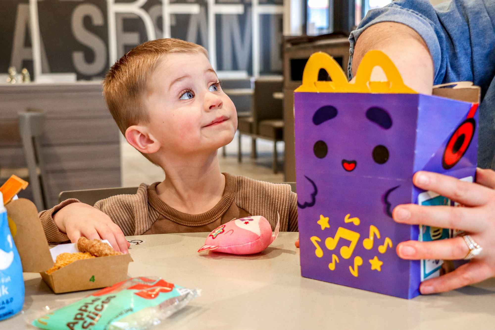 a child looking at a happy meal at mcdonalds