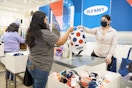 An Old Navy employee handing a customer her bag over the checkout counter at Old Navy.