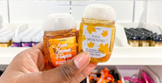 someone holding up some fall scented pocketbac hand sanitizers from Bath & Body Works