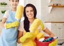 two people with cleaning aprons holding yellow dusters and cleaning products