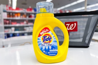 bottle of tide simply liquid detergent in front of walgreens shopping bag on store counter