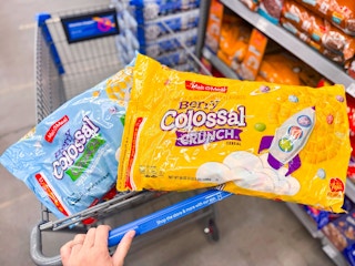 hand pushing cart with two bags of malt o meal cereal in walmart aisle