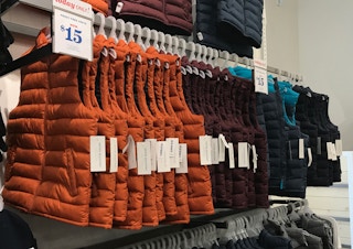puffer vests in store at old navy with a $15 sale sign