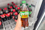 hand holding a bottle of sprite + tea at dollar general