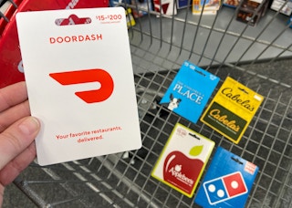 someone holding doordash gift card and other gift cards in cvs cart
