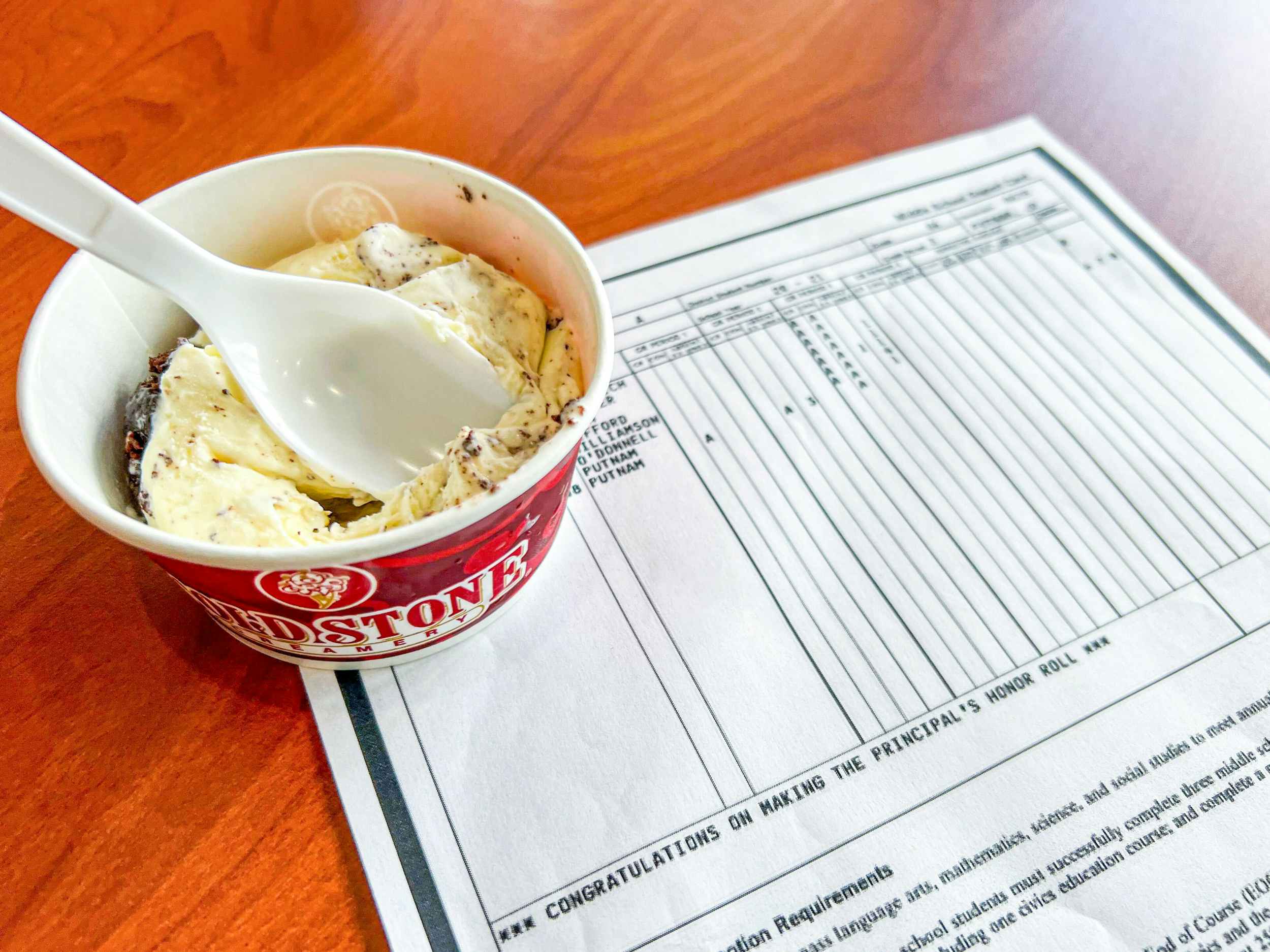 coldstone creamery ice cream next to a child's report card