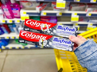 hand holding colgate maxfresh toothpastes
