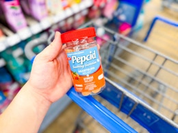 hand holding a bottle of Pepcid gummies