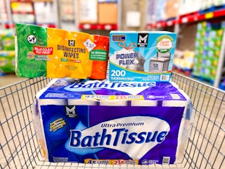 members mark toilet paper, trash bags, and disinfecting wipes in a cart
