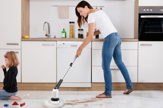 a woman cleaning her home with an electric spin scrubber