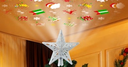 a star Christmas projector on top of a Christmas tree