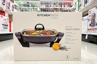 A box of Bella electric skillet in the middle of a Target aisle on the floor 