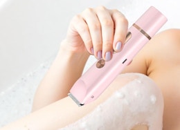 a person shaving their legs with a pink razor