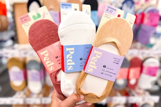 hand holding 3 peds women's socks at target