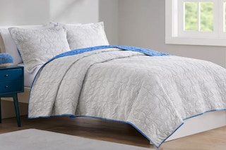 a blue and white reversible quilt set