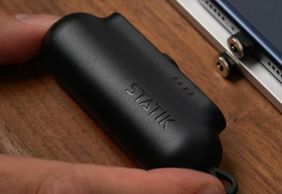 hand putting a black mini power bank into a table