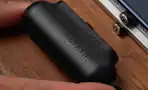 hand putting a black mini power bank into a table