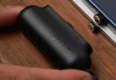 hand putting a black mini power bank into a table