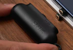 hand putting a black mini power bank into a table