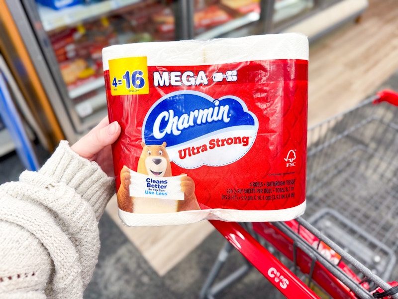 person holding charmin toilet paper over a cart