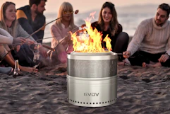 Lifestyle image of a group of friends at the beach roasting marshmallows around the fire