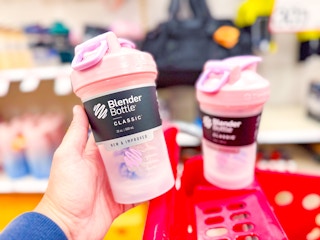 hand holding a blenderbottle classic shaker in front of a target cart