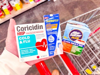 hand holding cold and flu medications