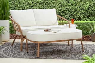 Lifestyle image of Better Homes & Gardens Wicker Patio Set outdoors with foliage around