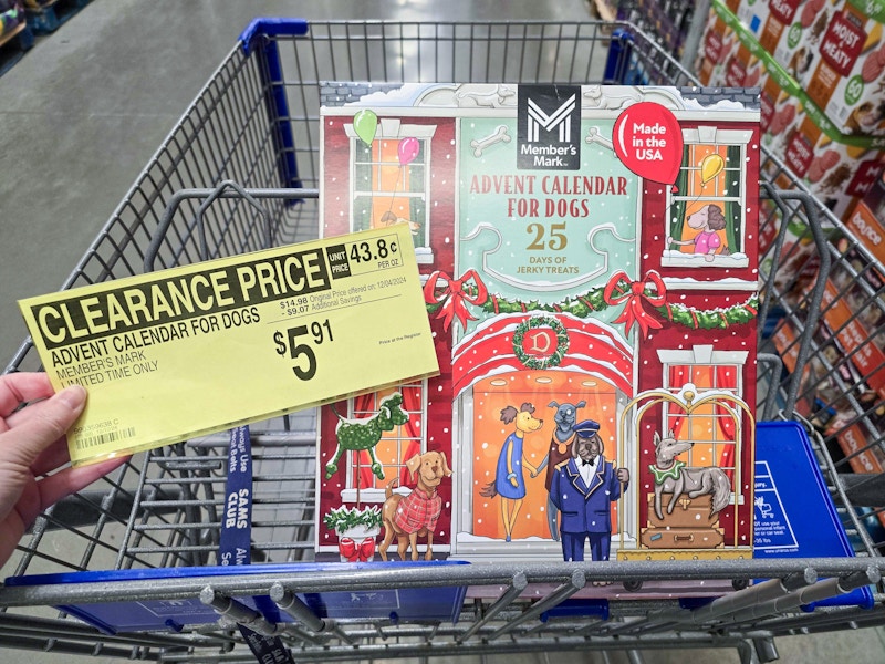 person holding a $5.91 clearance sign by a dog treat advent calendar in a cart