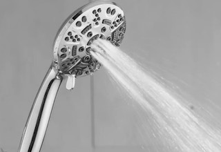 a silver shower head spraying water