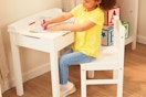 a girl coloring on a desk